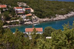 a house on the shore of a river with boats at Apartmani Marko in Gdinj