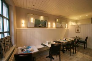 a dining room with tables and chairs and a mirror at Hotel Verdi in Rostock