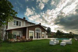 a house with a yard with chairs and a pool at Pasha Villas in Sapanca