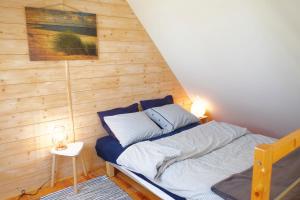 a bed in a room with a wooden wall at Domek Drewniany in Gdańsk