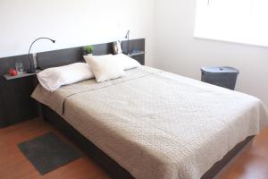 a bedroom with a large bed with two pillows at Cozy Apartment Vila do Bispo in Vila do Bispo