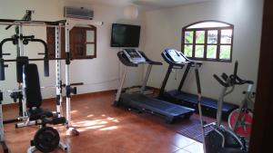 einen Fitnessraum mit mehreren Heimtrainern und einem TV in der Unterkunft Hotel Cacique Adiact in León