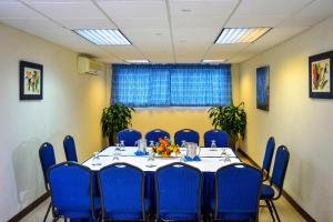 a meeting room with a table and blue chairs at Dover Beach Hotel in Christ Church +83 photos