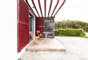 a patio with two chairs and a table on a house at Casa Da Poca Branca in Prainha de Baixo