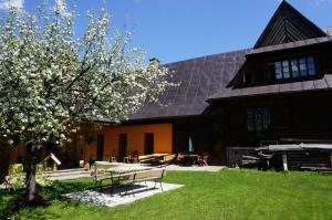 a building with a picnic table and a tree at Holiday Home Patchwork Barn in Zakopane