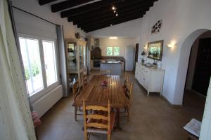 a kitchen and dining room with a wooden table and chairs at El Atarceder-6 - sea view villa with private pool in Benissa in Benissa