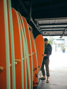 um homem ao lado de uma fileira de pranchas de surf em LOGE Westport em Westport
