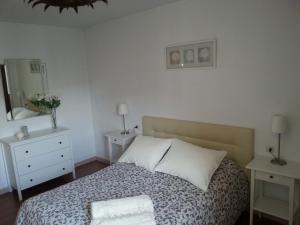 Schlafzimmer mit einem Bett, einer Kommode und einem Spiegel in der Unterkunft Playa Viginia in Málaga