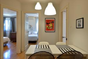 una habitación con mesa y sillas y un dormitorio en "San Giacomo Square Apt." in the heart of old town en Corfú
