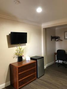 a room with a tv on the wall and a dresser at Fullerton Lodge in Fullerton