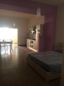 モルチャーノ・ディ・レウカにあるMonolocale del Salentoのベッドルーム1室(ベッド1台付)、キッチン、テーブルが備わります。