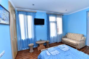 a blue room with a bed and a couch at Haghpat Hotel in Haghpat