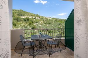 a table and chairs on a balcony with a view at Luxurious Apartments Maslina with Beach in Milna