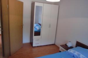 ein Schlafzimmer mit einem weißen Schrank mit Spiegel in der Unterkunft Apartment Andjel in Poreč