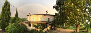 a yellow house with a rainbow in the background at La Source, Vegetarian Guest House in Chabeuil