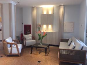 Champagnat Praia Hotel في فيلا فيلها: غرفة معيشة مع أريكة وكراسي وطاولة