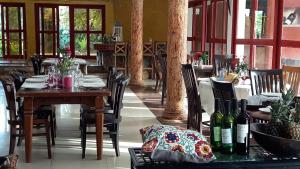 uma sala de jantar com uma mesa e cadeiras com garrafas de vinho em Accra Royal Castle Apartments & Suites em Kwabenya