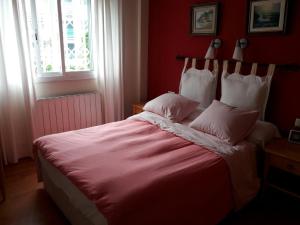 コマルガにあるBonito Apartamento Coma-Ruga / San Salvador Playa con Aire Acondicionadoの赤い壁のベッドルーム1室(大型ベッド1台付)