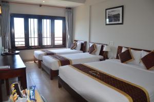 Postel nebo postele na pokoji v ubytování Sunshine Hoian Hotel