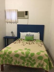 - un lit avec une couette verte et un oreiller dans l'établissement Hotel Florida, à Villahermosa