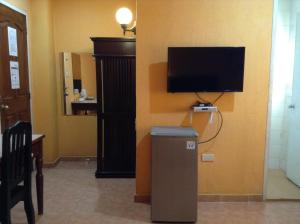 um quarto com uma televisão e um caixote do lixo em Miami Inn em Cagayan de Oro