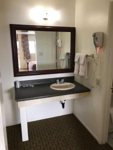 a bathroom with a sink and a mirror at American Inn in Las Vegas +29 photos