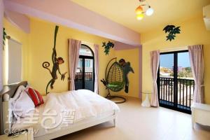 a bedroom with a bed with monkeys on the wall at Enjoy Summer in Magong