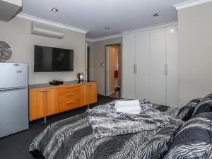 a living room with a bed and a television at New York On King in Perth