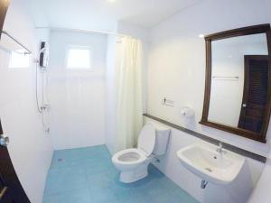 喀比的住宿－日出賓館，一间带卫生间、水槽和镜子的浴室