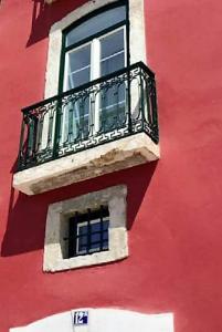 a red building with a window and a balcony at Hotel Riverside Alfama in Lisbon