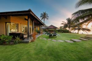 a house with a grass yard next to a building at Anantara Mui Ne Resort in Mui Ne