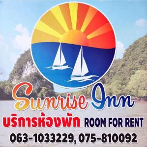 una señal para una posada de verano con un velero en el agua en Sunrise Inn en Krabi