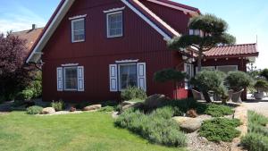 a red house with a garden in front of it at Harmony Park Nida House in Nida