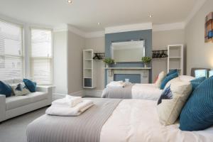 ポーツマスにあるStopover at ORCHARD GARDEN APARTMENT with great outdoor spaceのベッドルーム1室(ベッド2台、ソファ、暖炉付)