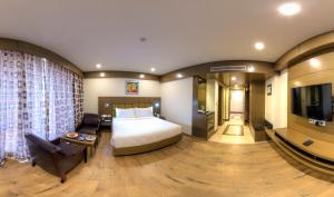 a hotel room with a bed and a television at Hotel Benzz Park Vellore in Vellore