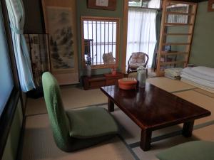 a living room with a table and a chair at Guesthouse Tamura in Nara