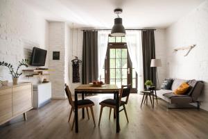 ein Wohnzimmer mit einem Tisch, Stühlen und einem Sofa in der Unterkunft Garden Studio in Krakau