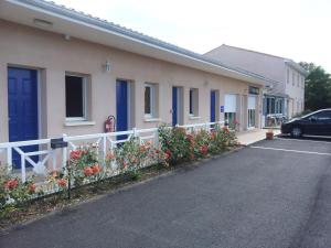 a row of houses with flowers in a parking lot at Tour Hôtel in Lesparre-Médoc