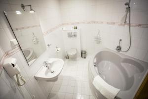 a bathroom with a tub and a toilet and a sink at Anielski Zakatek Polanczyk in Polańczyk