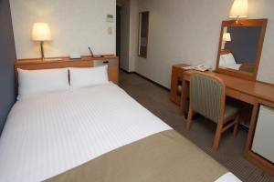 Postel nebo postele na pokoji v ubytování Toyooka Sky Hotel