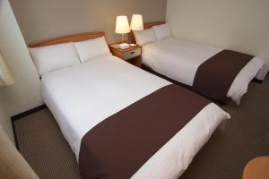 Postel nebo postele na pokoji v ubytování Toyooka Sky Hotel