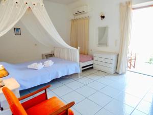 a bedroom with a bed and a chair at Filio Apartments in Kámbos +12 photos