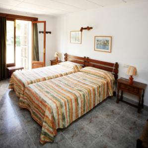 a bedroom with a large bed with a striped blanket at Villa Lorenzo in Cala Figuera