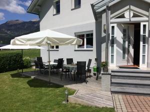 eine Terrasse mit einem Tisch, Stühlen und einem Sonnenschirm in der Unterkunft FerienFuchs in Gundersheim