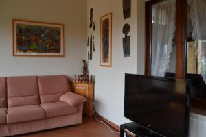 a living room with a couch and a flat screen tv at Villa La Veranda in Salò