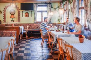 Eine Gruppe von Männern sitzt an Tischen in einem Restaurant in der Unterkunft Hotel Ertl in Kulmbach