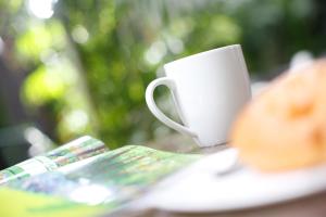 a cup of coffee and a plate with a donut at iclub To Kwa Wan Hotel in Hong Kong