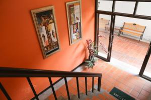 a staircase with orange walls and a vase of flowers at Penpark Place in Bangkok