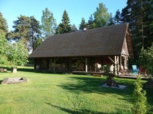 a large log cabin in a field of grass at Marknatalu Puhkemajad in Pärnu