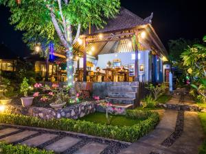ein Haus mit einem Garten in der Nacht mit Lichtern in der Unterkunft Bali Belva in Nusa Lembongan